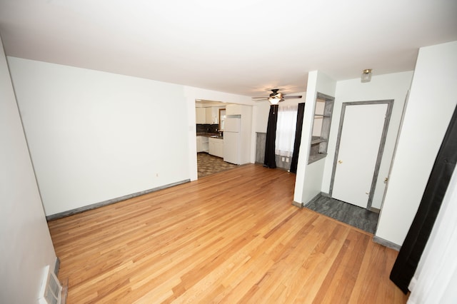 unfurnished living room featuring ceiling fan and light hardwood / wood-style flooring