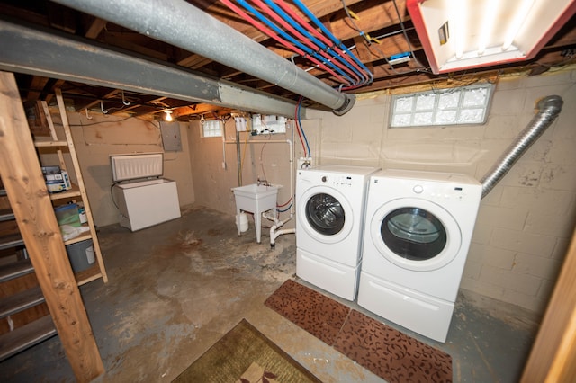 washroom with electric panel, separate washer and dryer, and sink