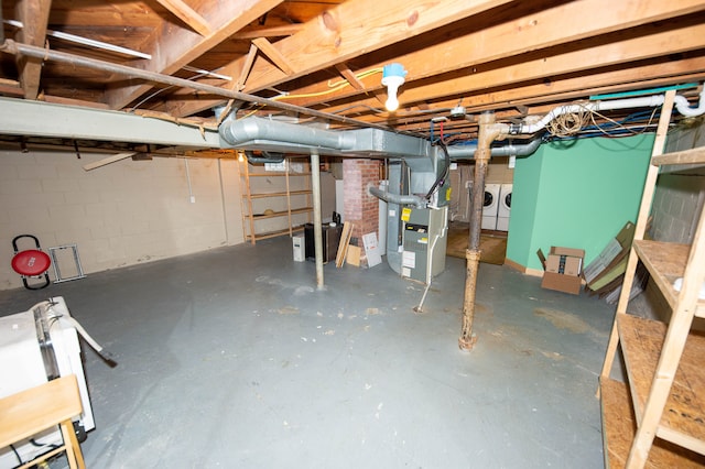 basement with heating unit and washing machine and dryer