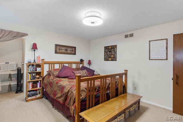 bedroom featuring light carpet and a textured ceiling