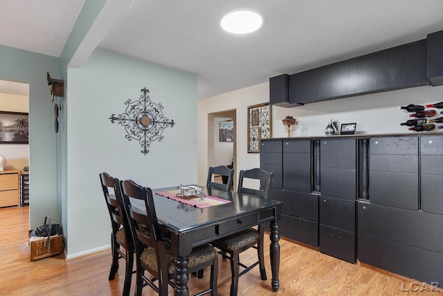 dining space featuring light hardwood / wood-style floors and beverage cooler