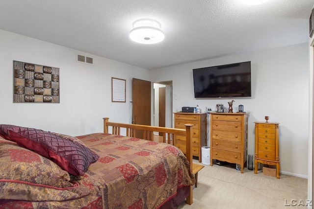 bedroom featuring light colored carpet and a textured ceiling