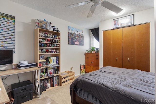 bedroom featuring ceiling fan, light carpet, a closet, and a textured ceiling