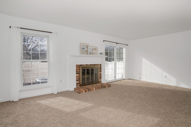 unfurnished living room featuring carpet flooring and a brick fireplace