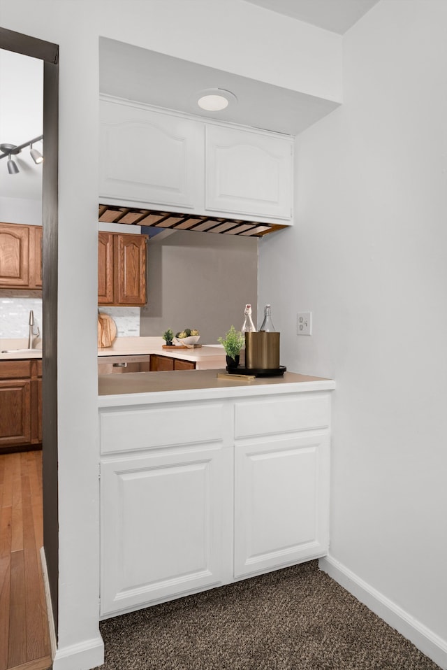 bar featuring white cabinetry, sink, and tasteful backsplash