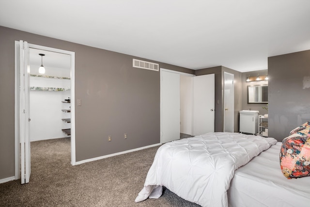 bedroom featuring connected bathroom and carpet floors