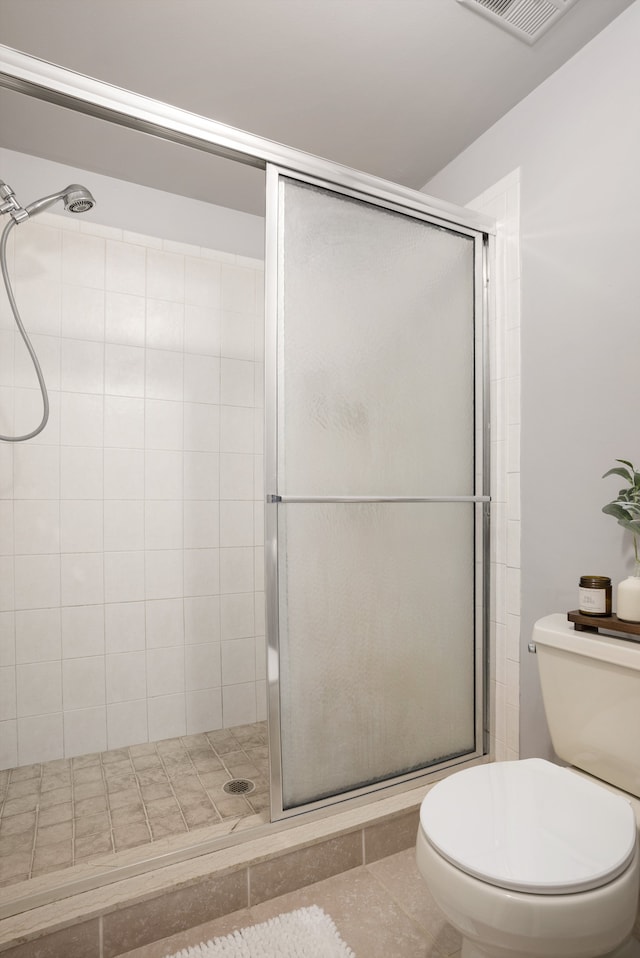 bathroom with an enclosed shower and toilet