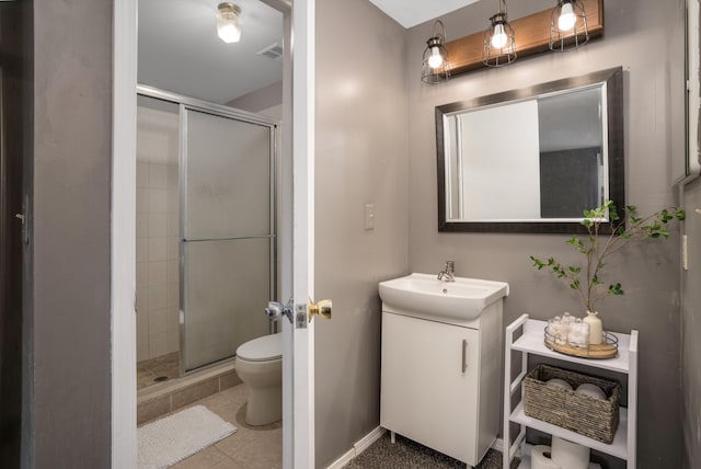 bathroom with vanity, tile patterned flooring, a shower with door, and toilet