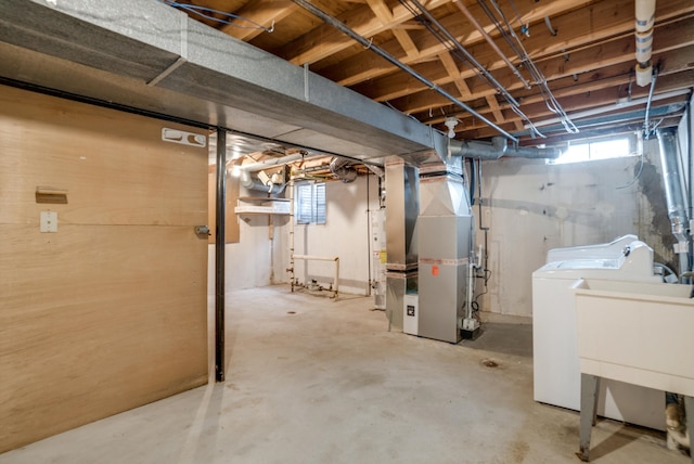 basement featuring washer / clothes dryer, sink, and heating unit