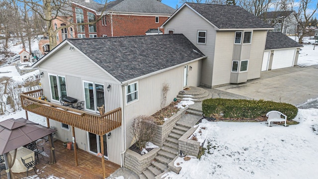 snow covered rear of property with a gazebo and a deck