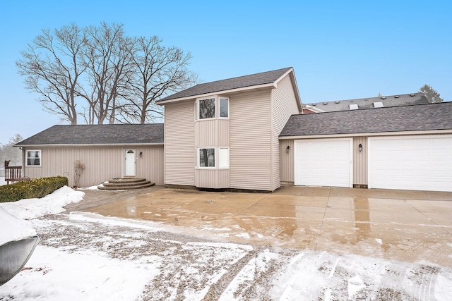 snow covered property with a garage