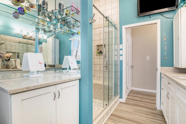 bathroom with a shower with door, vanity, and hardwood / wood-style floors