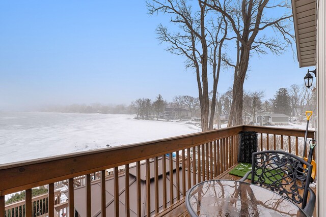 snow covered deck with a water view