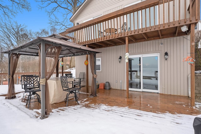 snow covered patio with a gazebo and a wooden deck