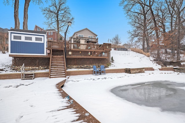 snow covered house featuring a wooden deck