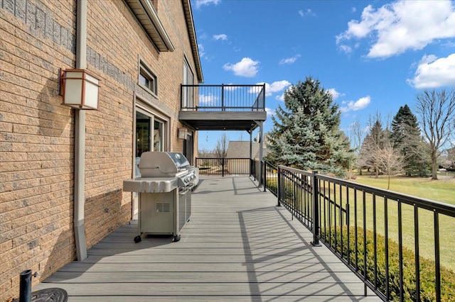 wooden terrace with grilling area and a yard