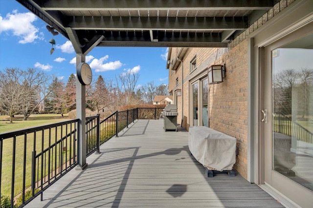 wooden terrace featuring grilling area and a lawn