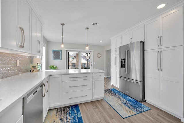 kitchen with visible vents, white cabinetry, stainless steel appliances, a peninsula, and light countertops