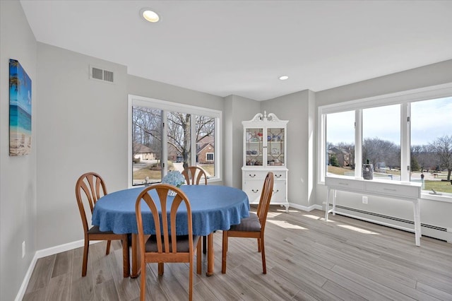 dining space with baseboards, visible vents, light wood finished floors, recessed lighting, and a baseboard heating unit