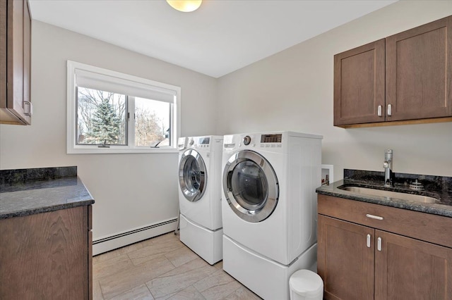 laundry area featuring a sink, a baseboard heating unit, cabinet space, and washing machine and dryer