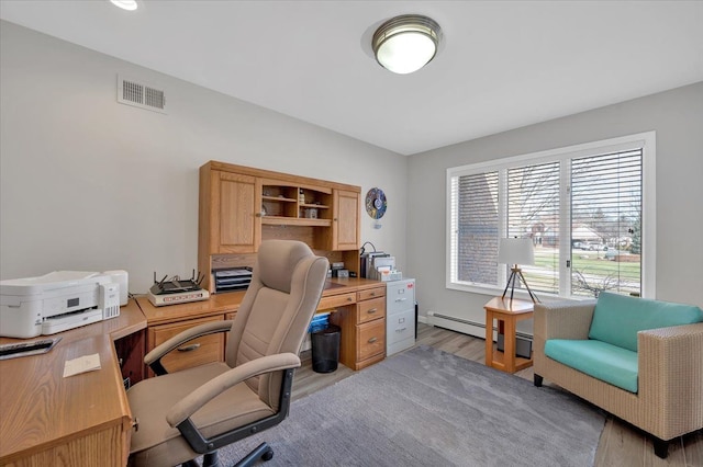 office area with light wood-type flooring, visible vents, and baseboard heating