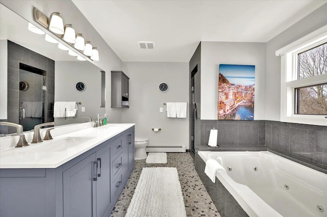 bathroom featuring double vanity, a stall shower, baseboard heating, and a sink