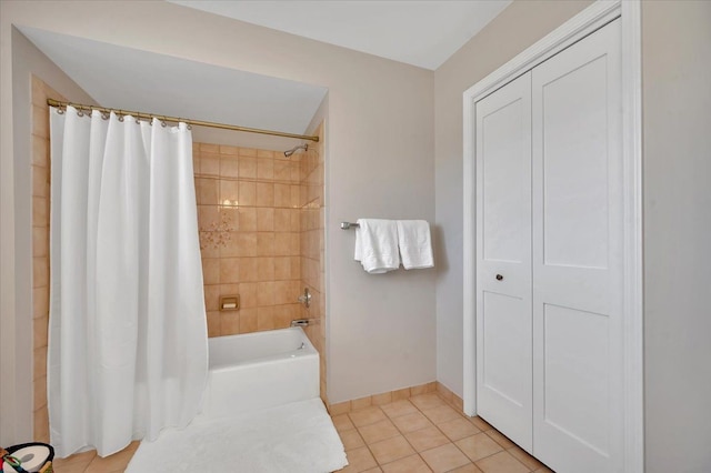 bathroom featuring tile patterned floors, baseboards, and shower / bath combo