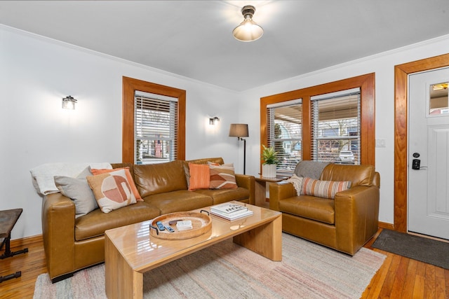 living room featuring ornamental molding, plenty of natural light, and light wood-type flooring