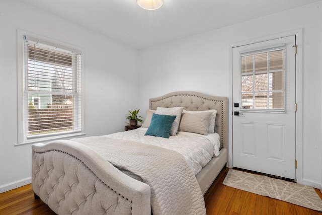 bedroom with multiple windows and hardwood / wood-style floors