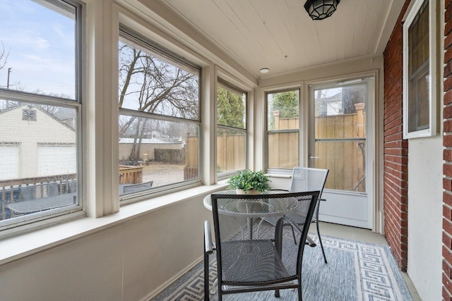 sunroom featuring a healthy amount of sunlight and wood ceiling