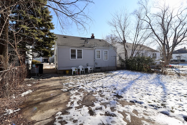 view of snow covered rear of property