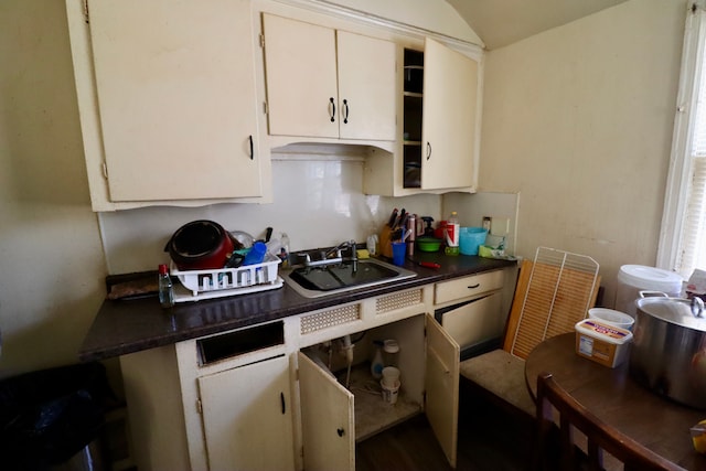 kitchen featuring vaulted ceiling and sink