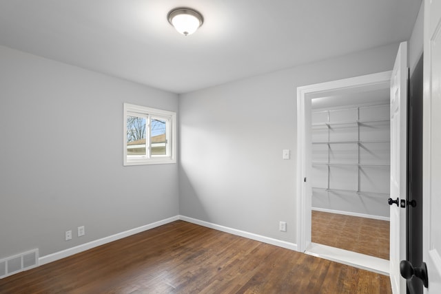 unfurnished bedroom with dark hardwood / wood-style flooring and a closet