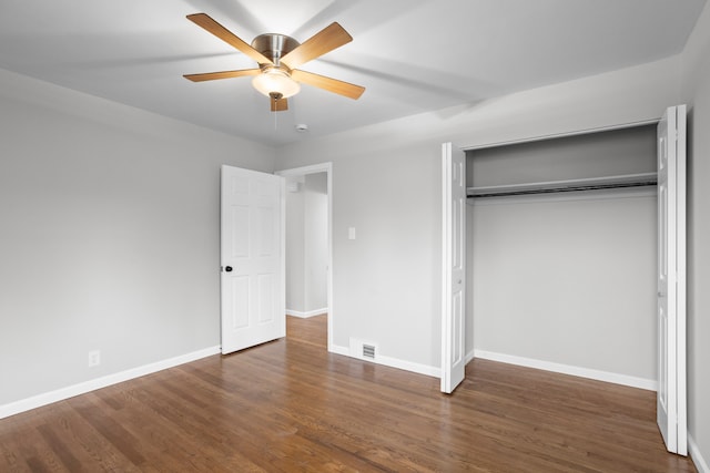 unfurnished bedroom featuring dark hardwood / wood-style floors, ceiling fan, and a closet