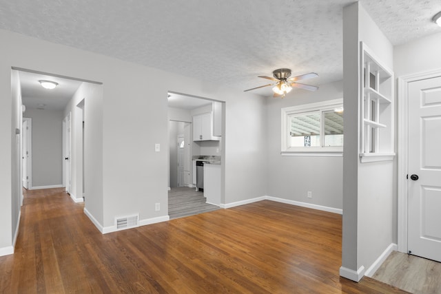 unfurnished living room featuring ceiling fan, hardwood / wood-style flooring, and a textured ceiling