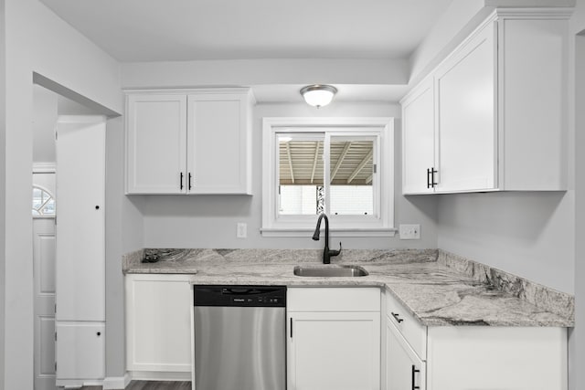 kitchen with white cabinetry, stainless steel dishwasher, sink, and light stone counters