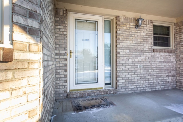 view of exterior entry with brick siding