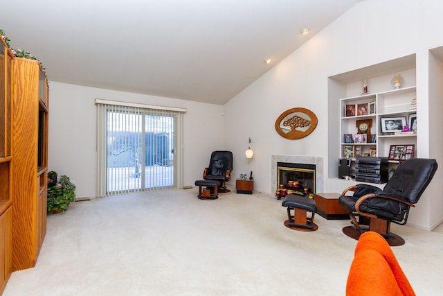 sitting room featuring recessed lighting, vaulted ceiling, light colored carpet, and a glass covered fireplace