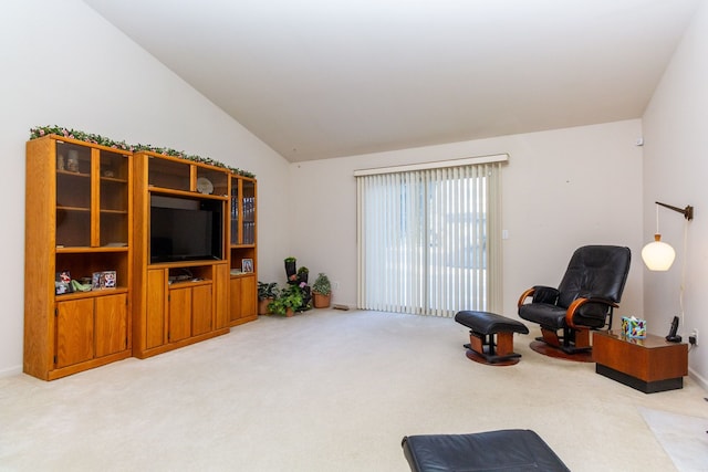living area with light colored carpet and vaulted ceiling