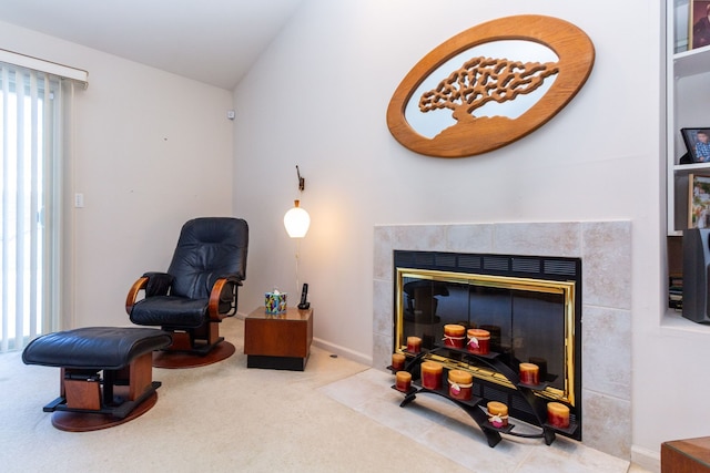 sitting room with a tile fireplace, vaulted ceiling, plenty of natural light, and carpet flooring