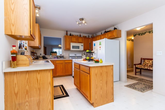 kitchen with a sink, light countertops, a center island, light floors, and white appliances