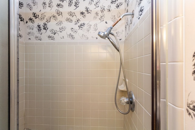 room details featuring a shower stall and wallpapered walls