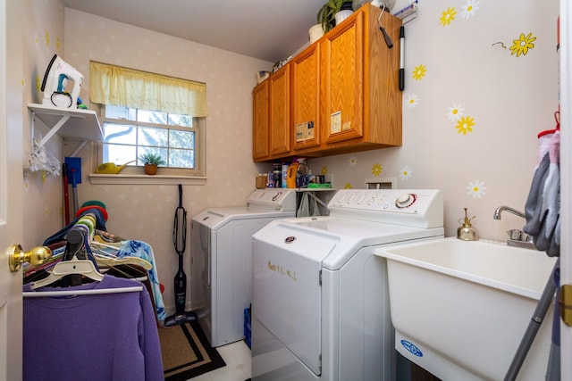 laundry area featuring sink, washer and clothes dryer, and cabinets