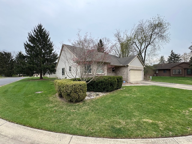 ranch-style house featuring concrete driveway, a front yard, an attached garage, and brick siding