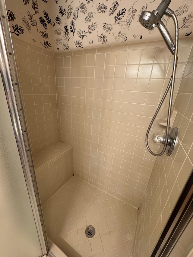 full bathroom featuring a shower stall and wallpapered walls