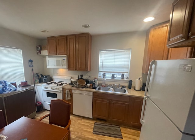 kitchen with sink, white appliances, and light hardwood / wood-style floors