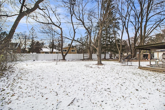 yard layered in snow featuring a deck