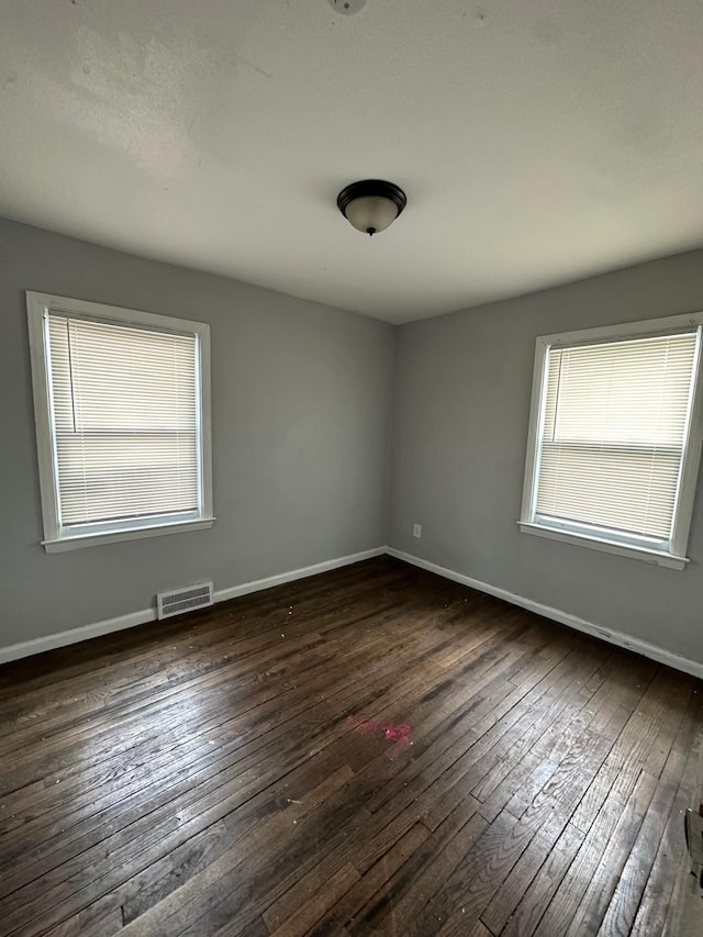 unfurnished room featuring dark wood-type flooring