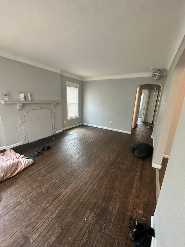 unfurnished living room featuring dark hardwood / wood-style floors and a textured ceiling