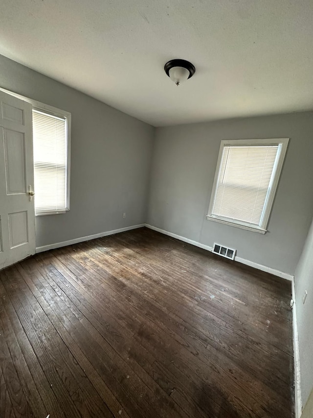 spare room with dark wood-type flooring